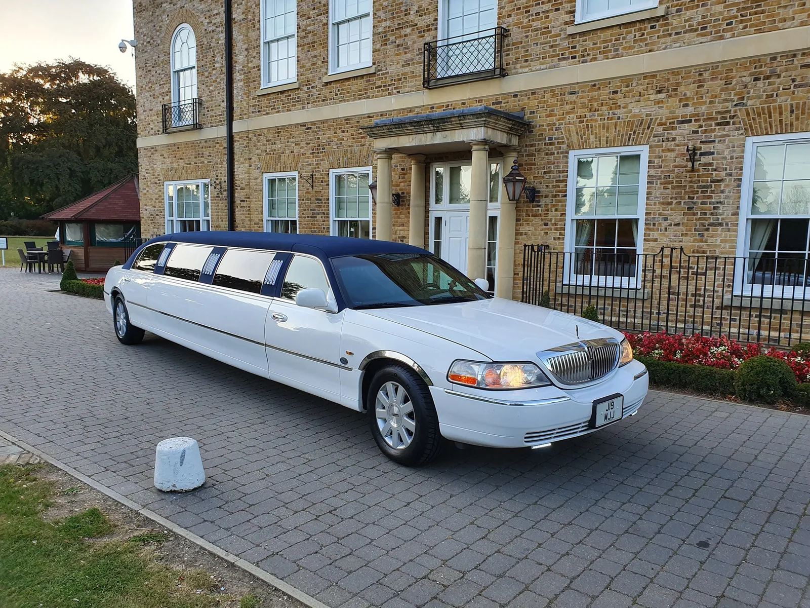 White Tuxedo style limo parked outside a venue